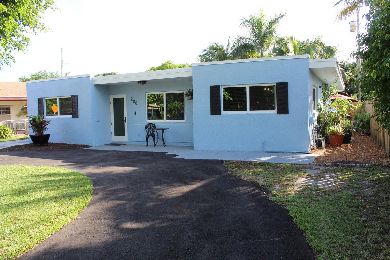 200 Lancaster Street Boca Raton, FL 33487 - Photo 2 of 43 a front view of a house with a yard and garage