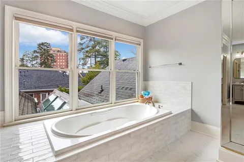a bathroom with a tub a sink and a large window