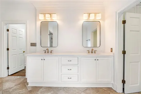 a bathroom with double vanity sinks and a mirror