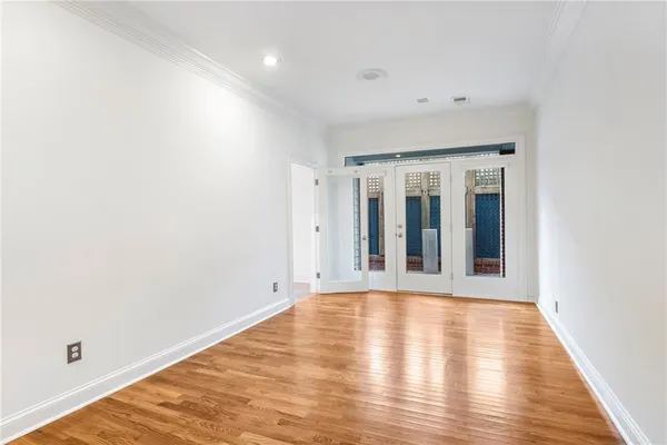 a view of an empty room with wooden floor