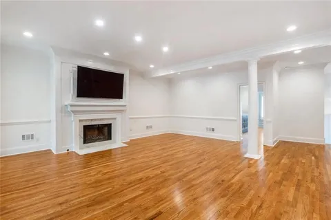 a view of empty room with wooden floor and fireplace