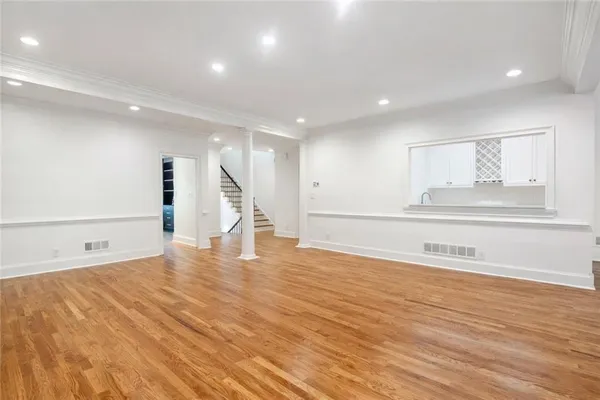 a view of empty room with wooden floor
