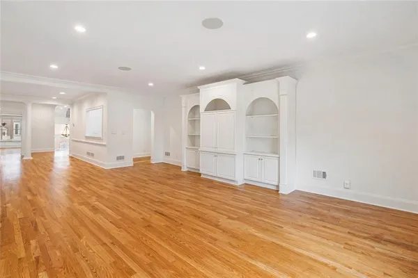 a view of empty room with wooden floor
