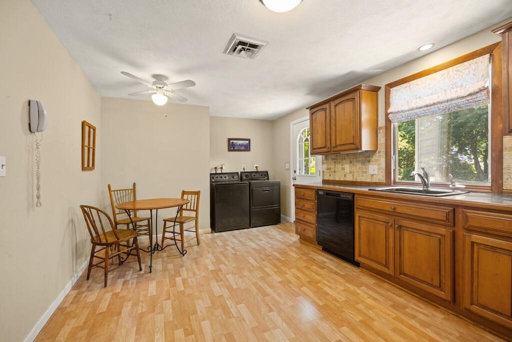 11 Rickey Drive Maynard, MA 01754 - Photo 9 of 29 a kitchen with stainless steel appliances granite countertop a stove top oven a sink dishwasher a dining table and chairs with wooden floor