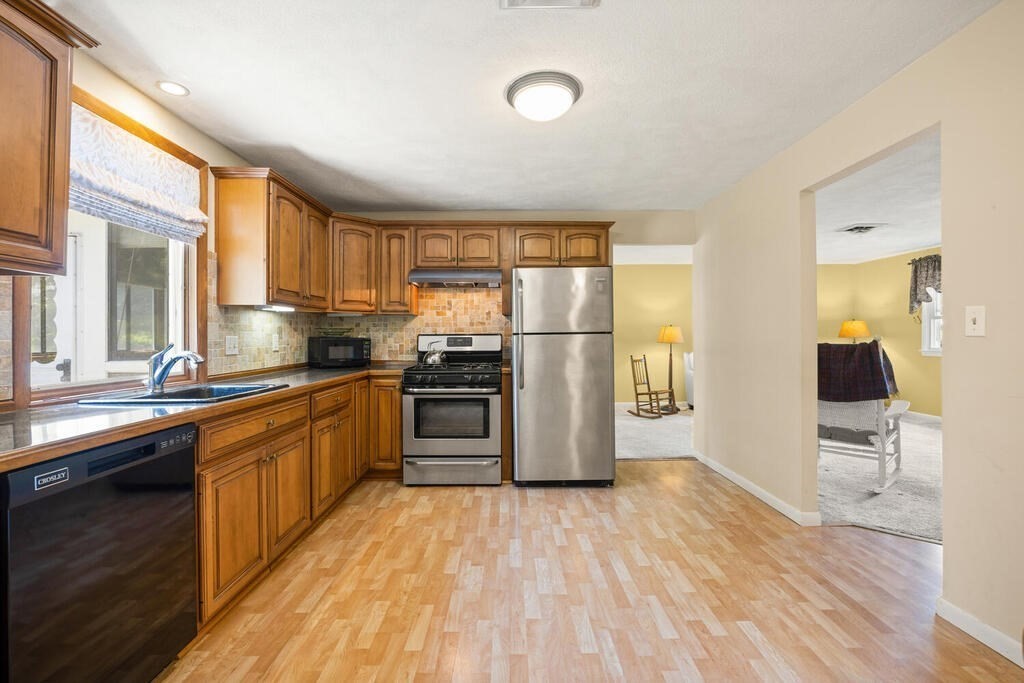 11 Rickey Drive Maynard, MA 01754 - Photo 10 of 29 a kitchen with stainless steel appliances a refrigerator and wooden cabinets
