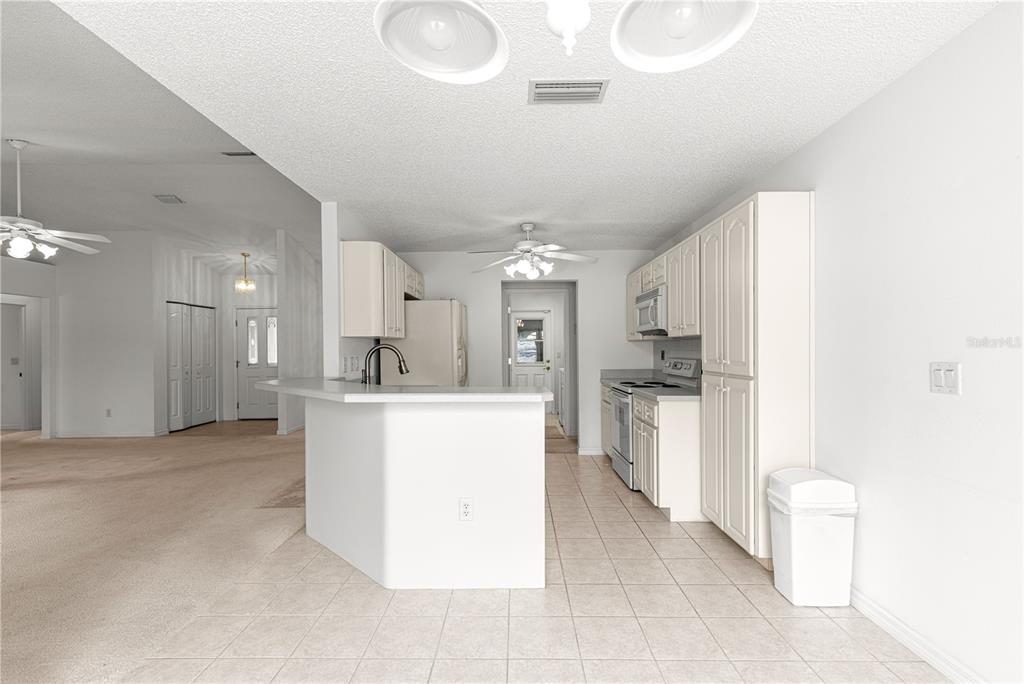 5312 Southwest 109th Place Road Ocala, FL 34476 - Photo 11 of 39 a large kitchen with a large counter top a sink stainless steel appliances and cabinets