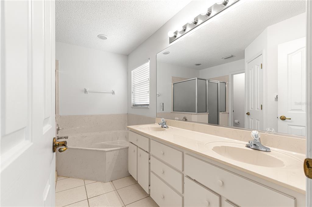 5312 Southwest 109th Place Road Ocala, FL 34476 - Photo 22 of 39 a bathroom with a sink double vanity granite tub shower and a mirror