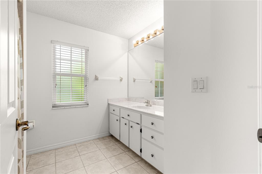5312 Southwest 109th Place Road Ocala, FL 34476 - Photo 29 of 39 a bathroom with a double vanity sink a mirror and a bathtub