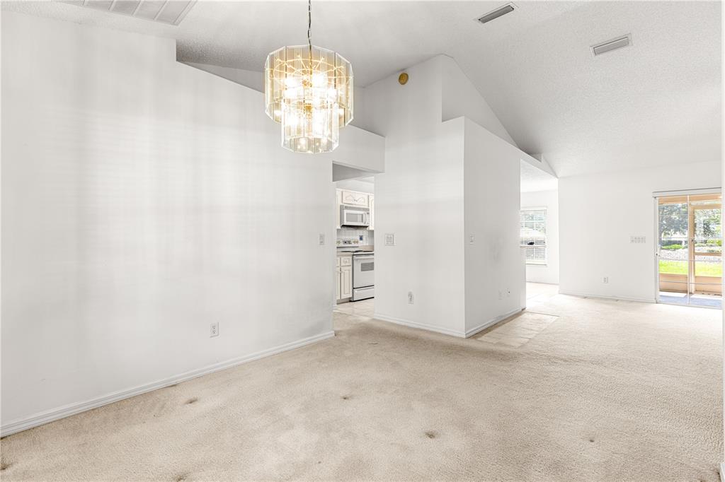 5312 Southwest 109th Place Road Ocala, FL 34476 - Photo 4 of 39 an empty room with chandelier and windows