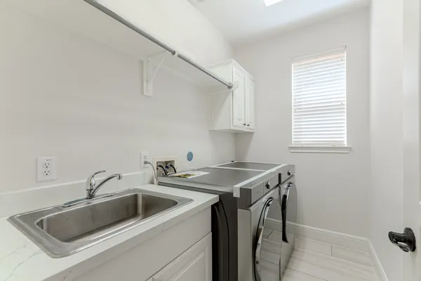a utility room with sink dryer and washer