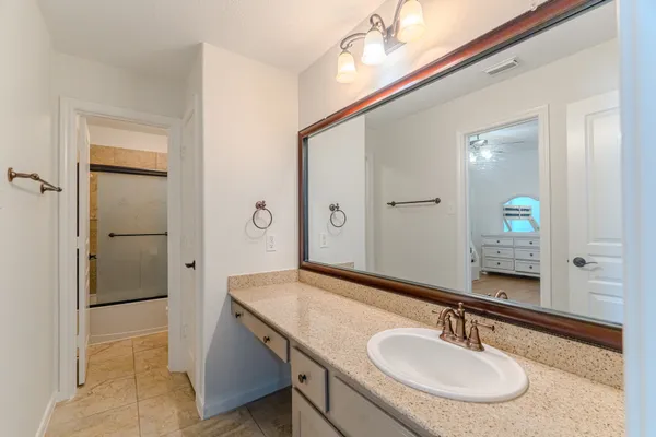 a bathroom with a sink a light fixture and a mirror
