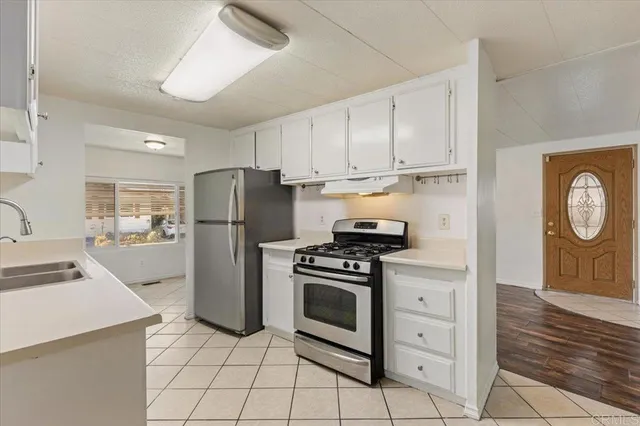 a kitchen with a stove a refrigerator and a cabinets