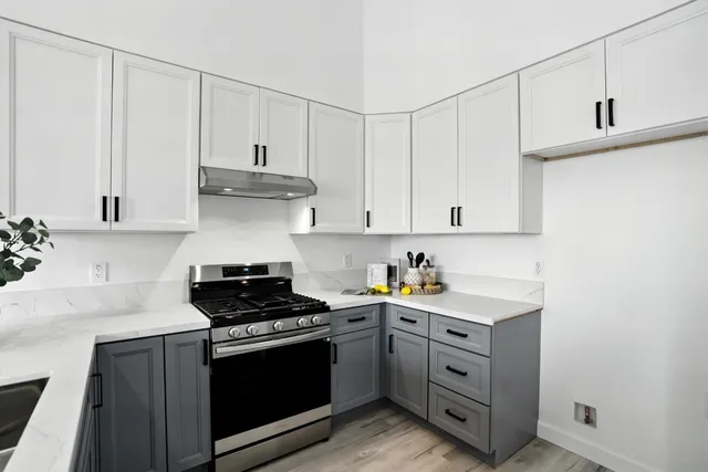 a kitchen with white cabinets and white appliances