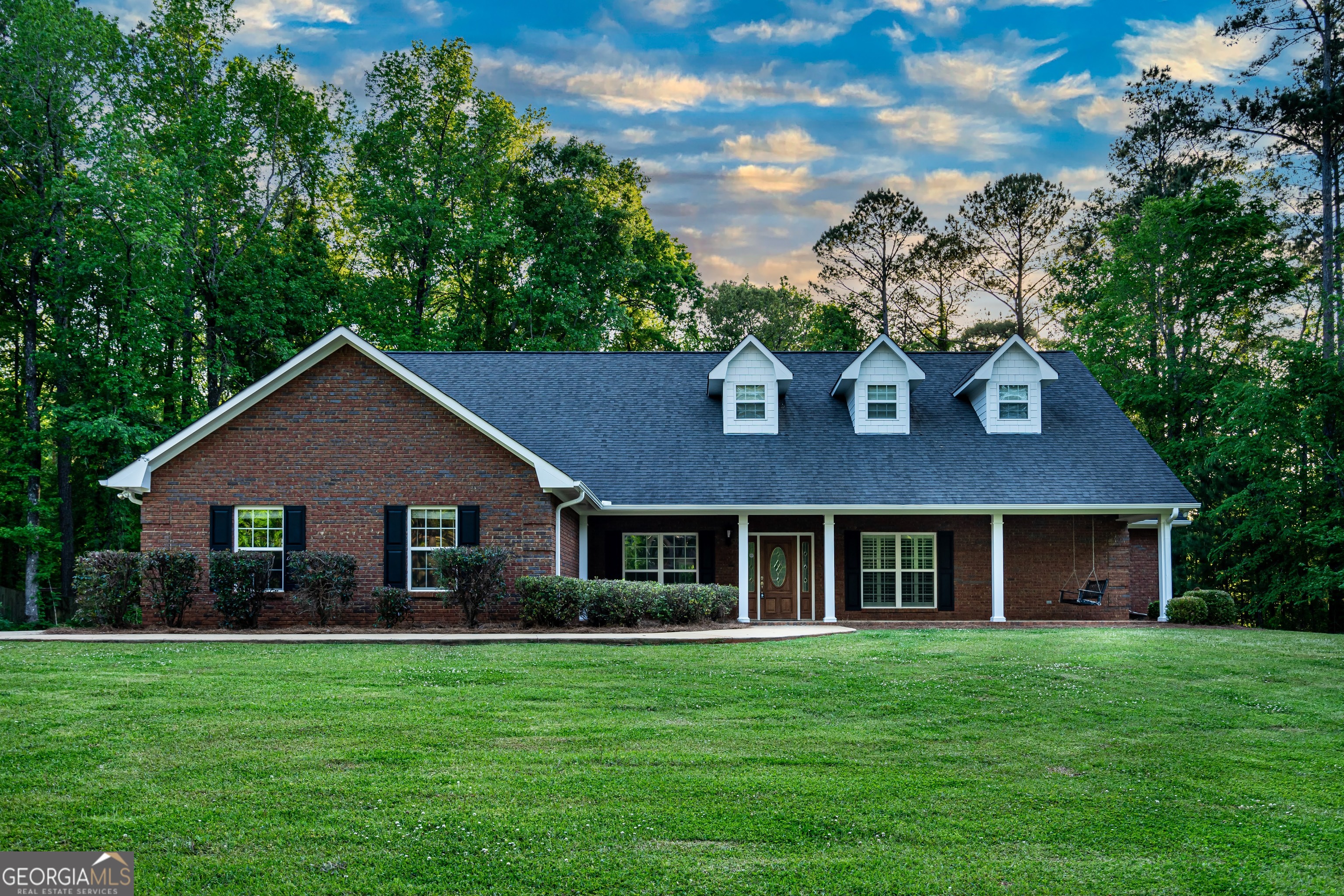a front view of a house with a garden