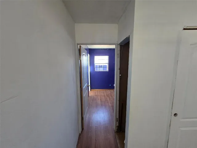 a view of a hallway with wooden floor and closet