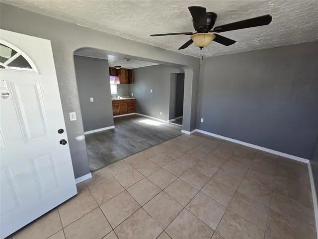 a view of a livingroom with a chandelier fan and wooden floor