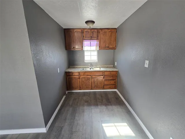 a view of hallway with window and wooden floor
