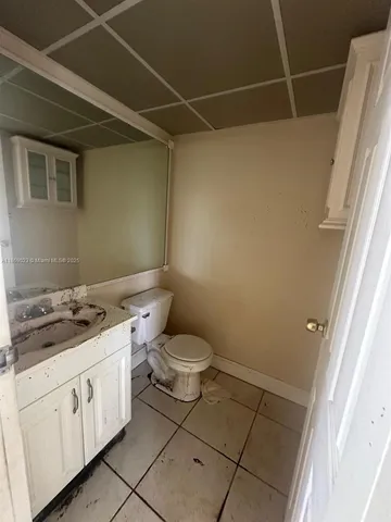 an empty room with windows and chandelier fan