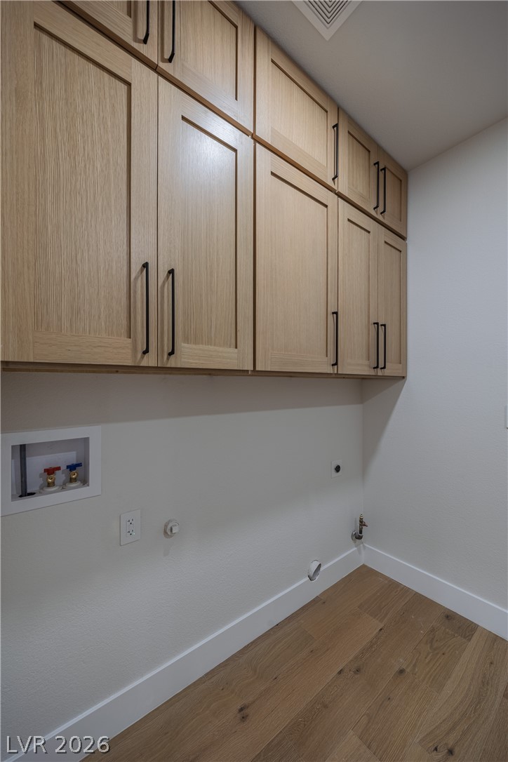 8800 Lusso Las Vegas, NV 89134 - Photo 55 of 85 Laundry room with gas dryer hookup, cabinet space, washer hookup, hardwood / wood-style floors, and electric dryer hookup