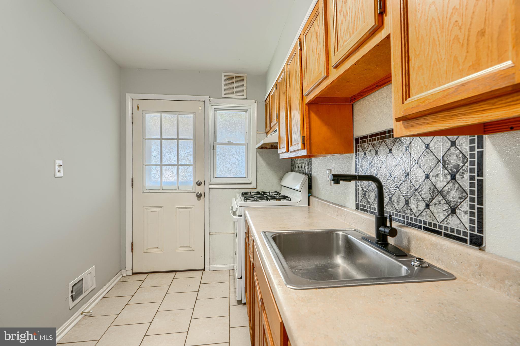 2073 Jasmine Road Baltimore, MD 21222 - Photo 8 of 29 a kitchen with a sink a stove and cabinets
