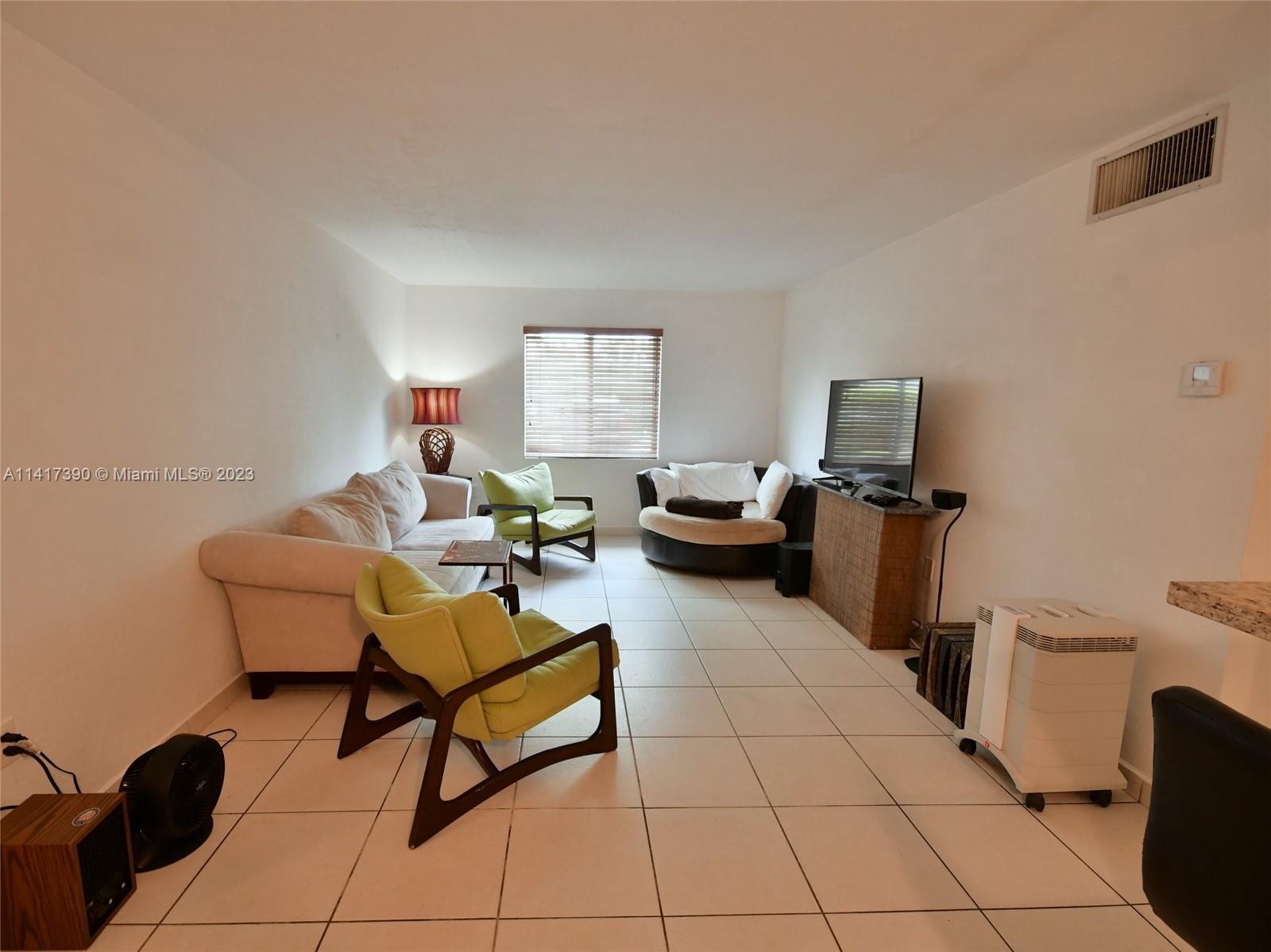 8609 Southwest 68th Court, Unit 5 Pinecrest, FL 33156 - Photo 11 of 27 a living room with furniture a flat screen tv and a window