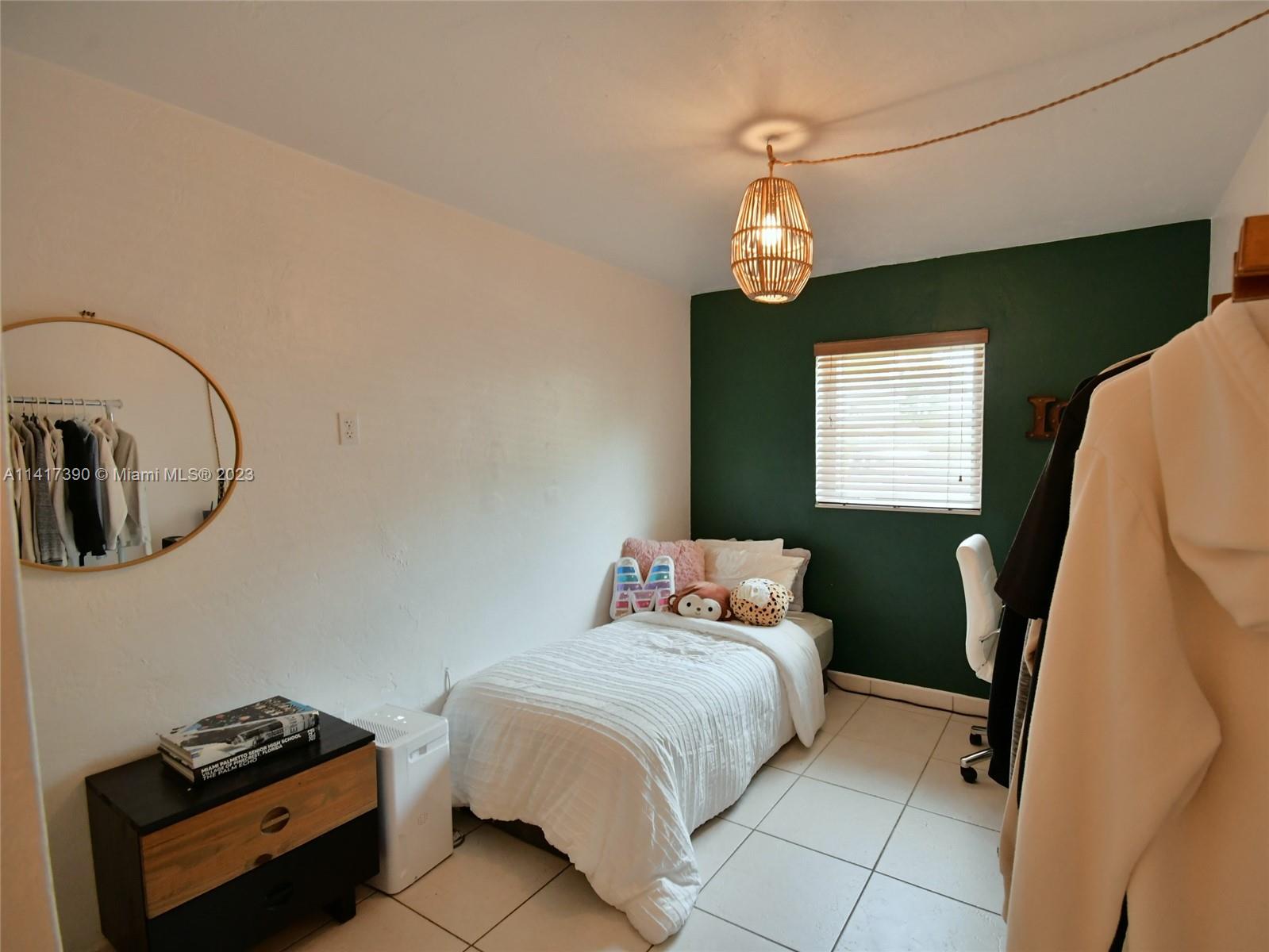 8609 Southwest 68th Court, Unit 5 Pinecrest, FL 33156 - Photo 16 of 27 a bedroom with a bed and a window