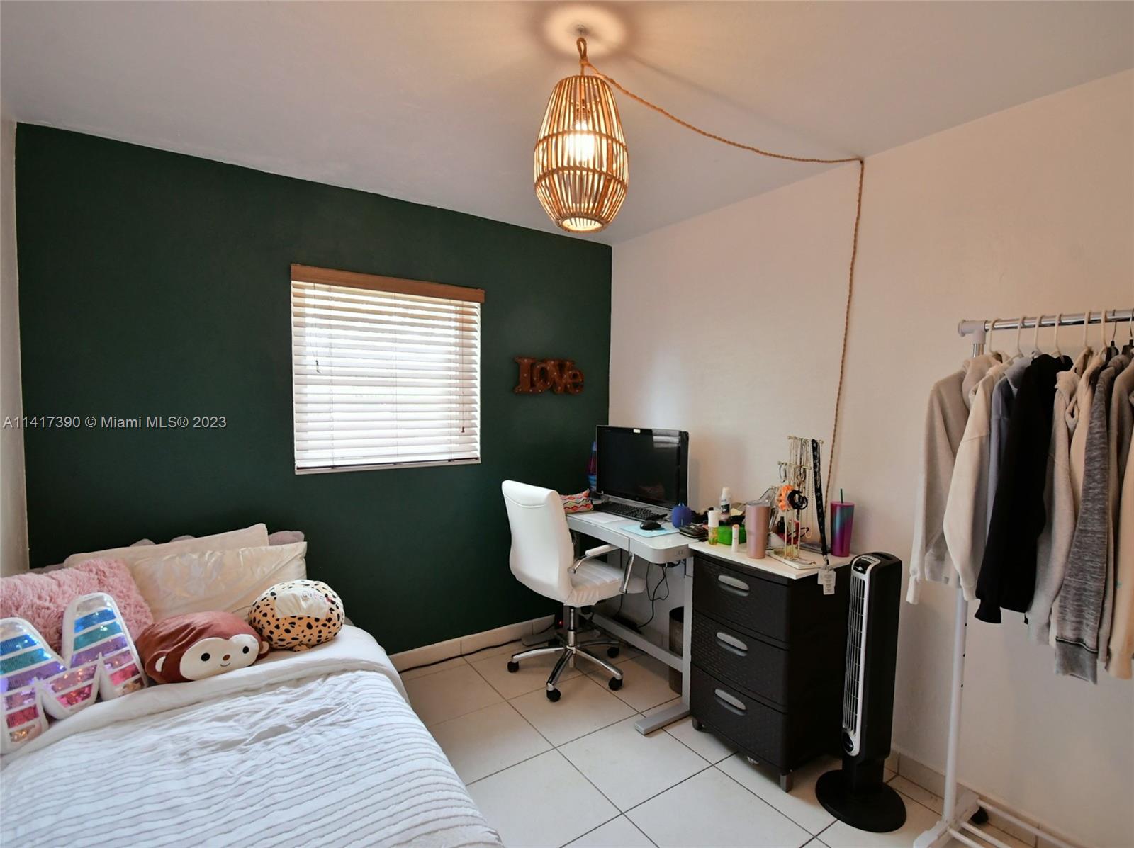 8609 Southwest 68th Court, Unit 5 Pinecrest, FL 33156 - Photo 20 of 27 a bedroom with a bed and flat screen tv