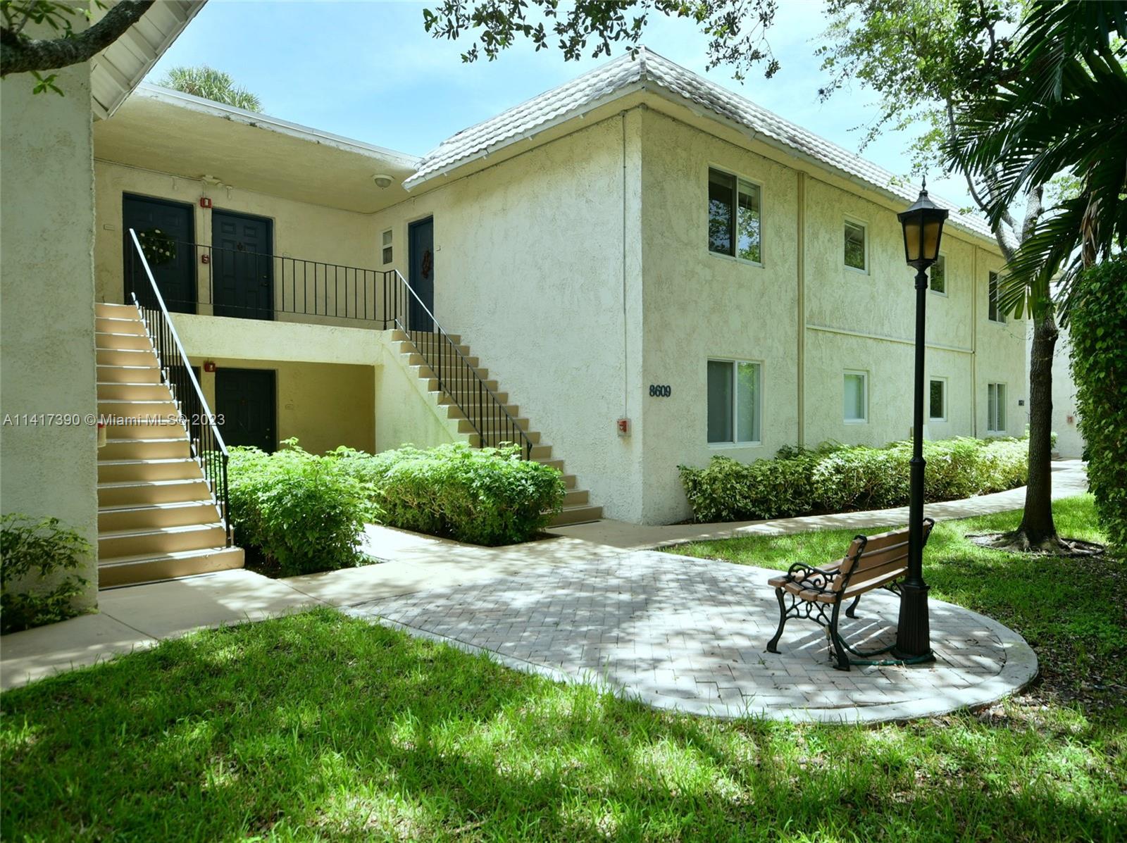8609 Southwest 68th Court, Unit 5 Pinecrest, FL 33156 - Photo 2 of 27 a view of a chair and table in backyard of the house