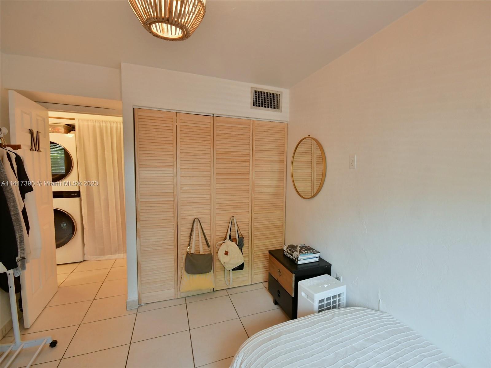 8609 Southwest 68th Court, Unit 5 Pinecrest, FL 33156 - Photo 22 of 27 a bathroom with a toilet mirror and vanity