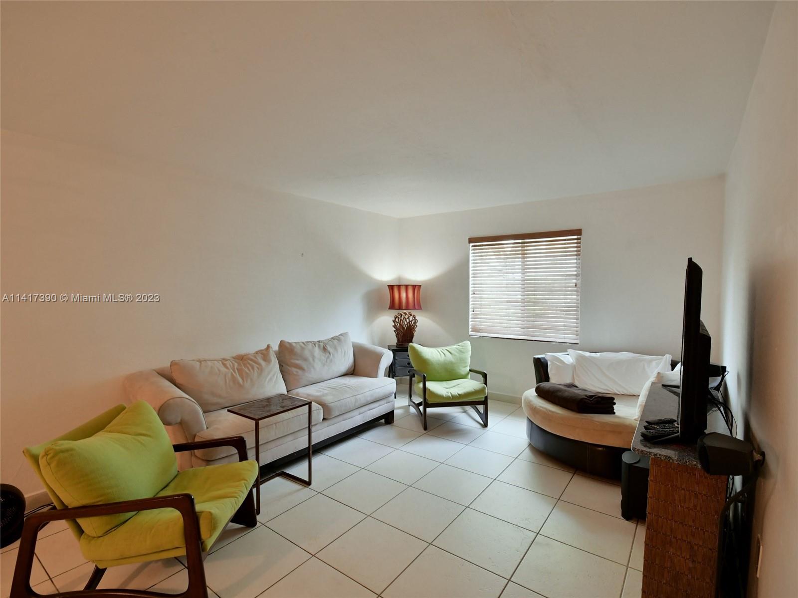 8609 Southwest 68th Court, Unit 5 Pinecrest, FL 33156 - Photo 3 of 27 a living room with furniture and a window