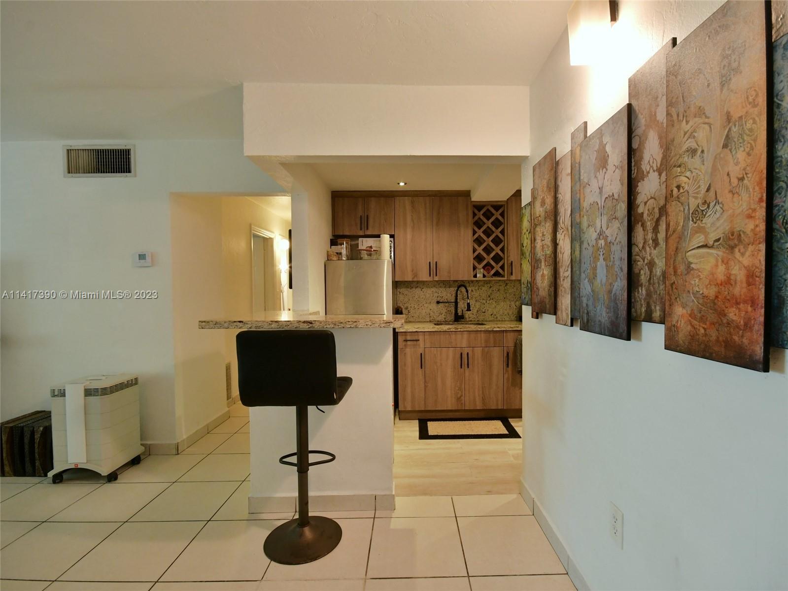 8609 Southwest 68th Court, Unit 5 Pinecrest, FL 33156 - Photo 4 of 27 a living room with a couch and a potted plant