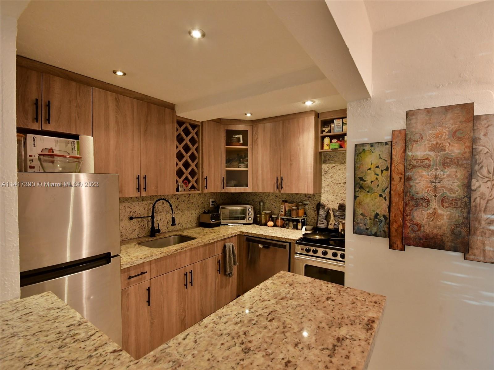 8609 Southwest 68th Court, Unit 5 Pinecrest, FL 33156 - Photo 5 of 27 a kitchen with stainless steel appliances granite countertop a sink stove and refrigerator