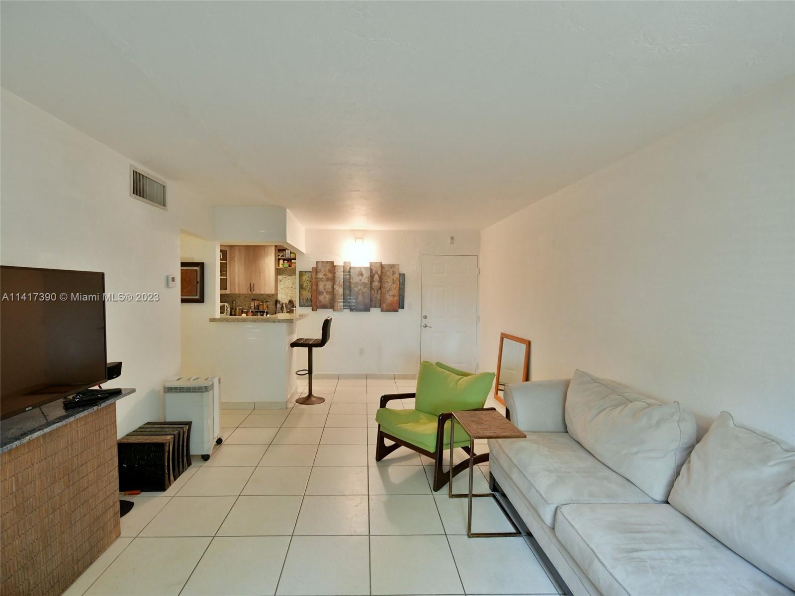 8609 Southwest 68th Court, Unit 5 Pinecrest, FL 33156 - Photo 6 of 27 a living room with furniture and a flat screen tv