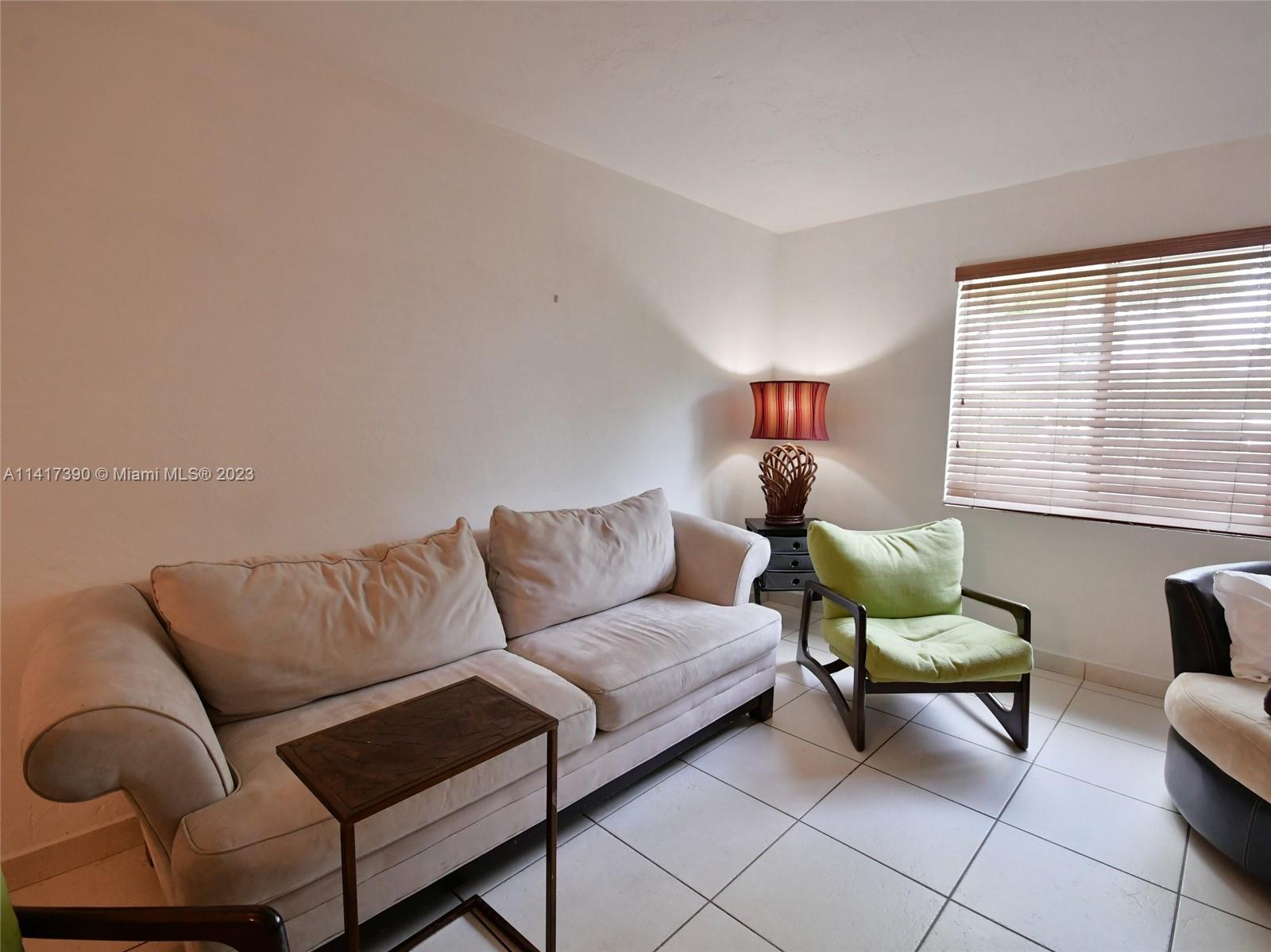 8609 Southwest 68th Court, Unit 5 Pinecrest, FL 33156 - Photo 10 of 27 a living room with furniture and a window
