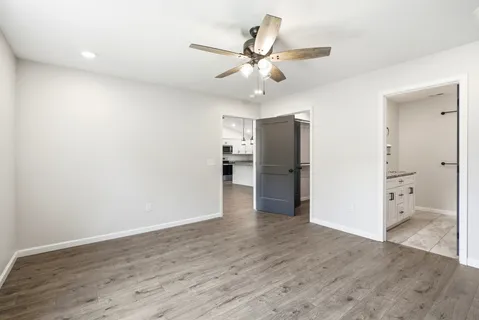 an empty room with fan and windows