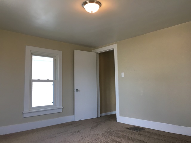 749 Spring Street Aurora, IL 60505 - Photo 15 of 18 an empty room with wooden floor cabinet and windows