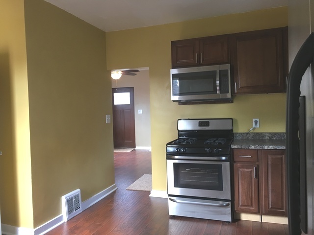 749 Spring Street Aurora, IL 60505 - Photo 7 of 18 a kitchen with granite countertop wooden cabinets and stainless steel appliances