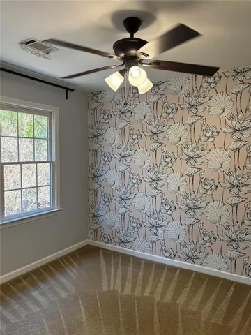 an empty room with a window and a fan