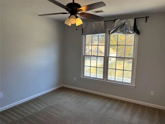 a view of room with a ceiling fan and window