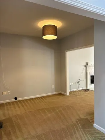 a view of an empty room with a fireplace and a window