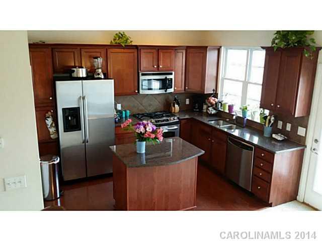 589 6th Baxter Crossing, Unit 5 Fort Mill, SC 29708 - Photo 4 of 12 a kitchen with a refrigerator sink and wooden cabinets