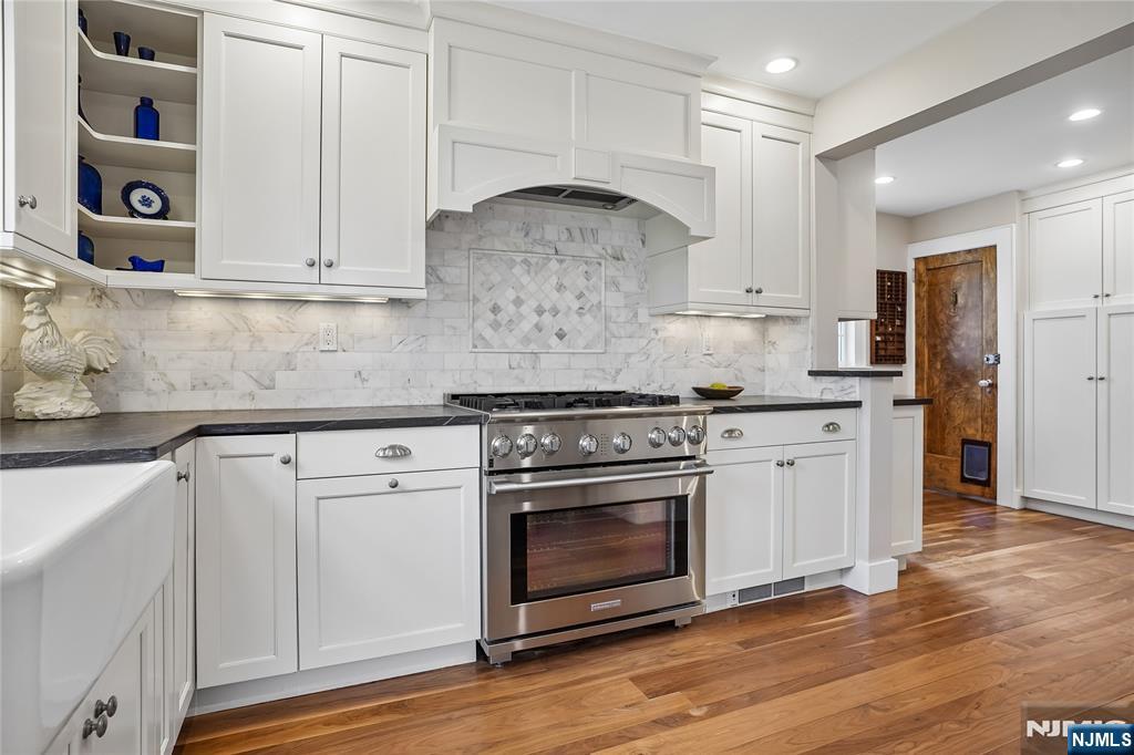 25 Bowers Road Caldwell, NJ 07006 - Photo 12 of 37 a kitchen with stainless steel appliances granite countertop a stove and white cabinets