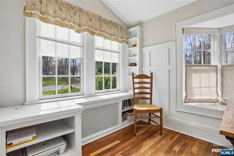 a bedroom with a bed and a dresser with wooden floor