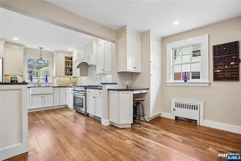 a kitchen with stainless steel appliances granite countertop a stove and white cabinets