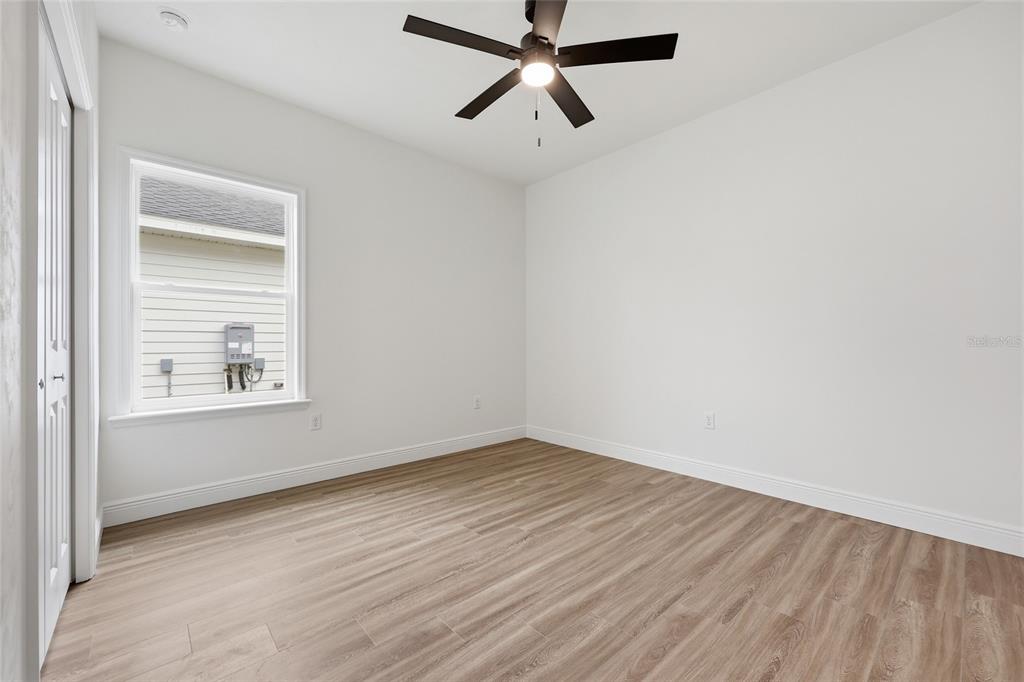 6735 Southwest 10th Lane Gainesville, FL 32607 - Photo 15 of 24 an empty room with wooden floor ceiling fan and windows