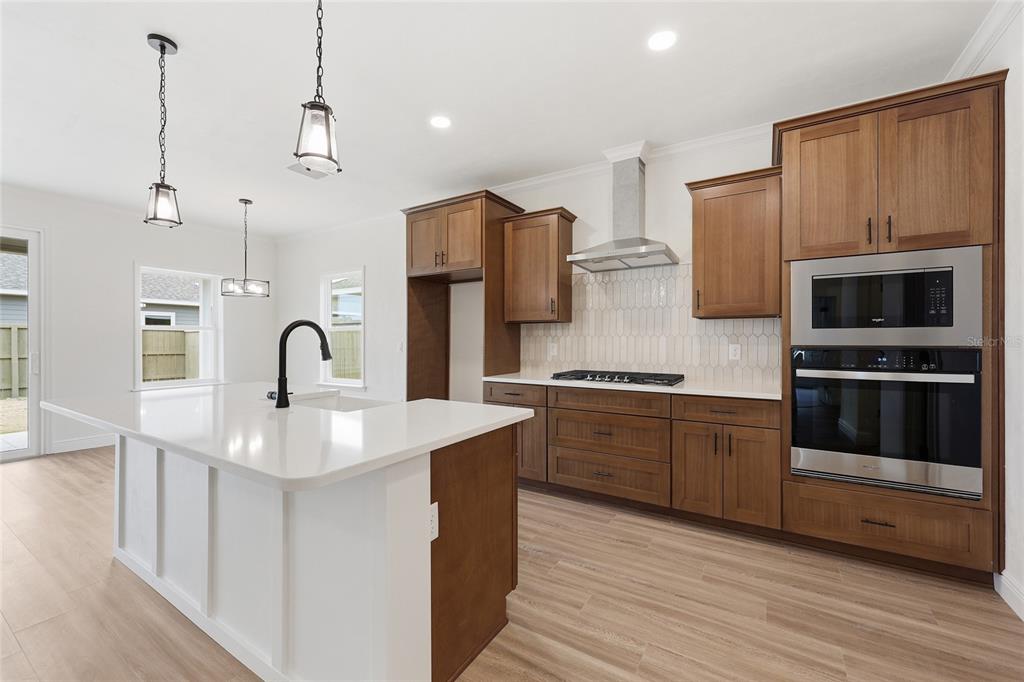 6735 Southwest 10th Lane Gainesville, FL 32607 - Photo 5 of 24 a kitchen with stainless steel appliances a stove a sink a microwave a refrigerator and cabinets