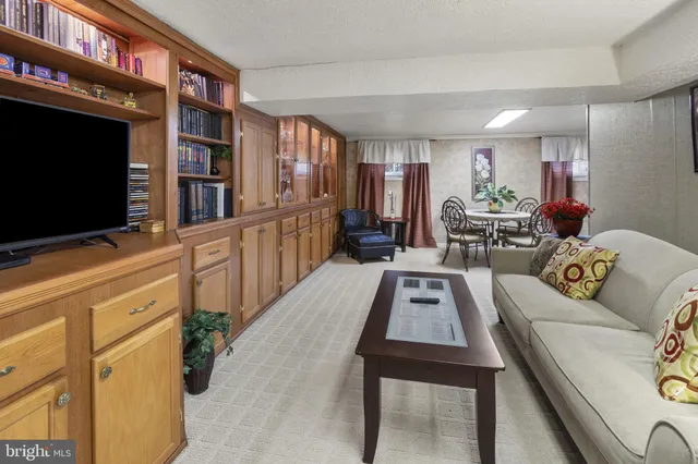 a living room with furniture a flat screen tv and a bookshelf