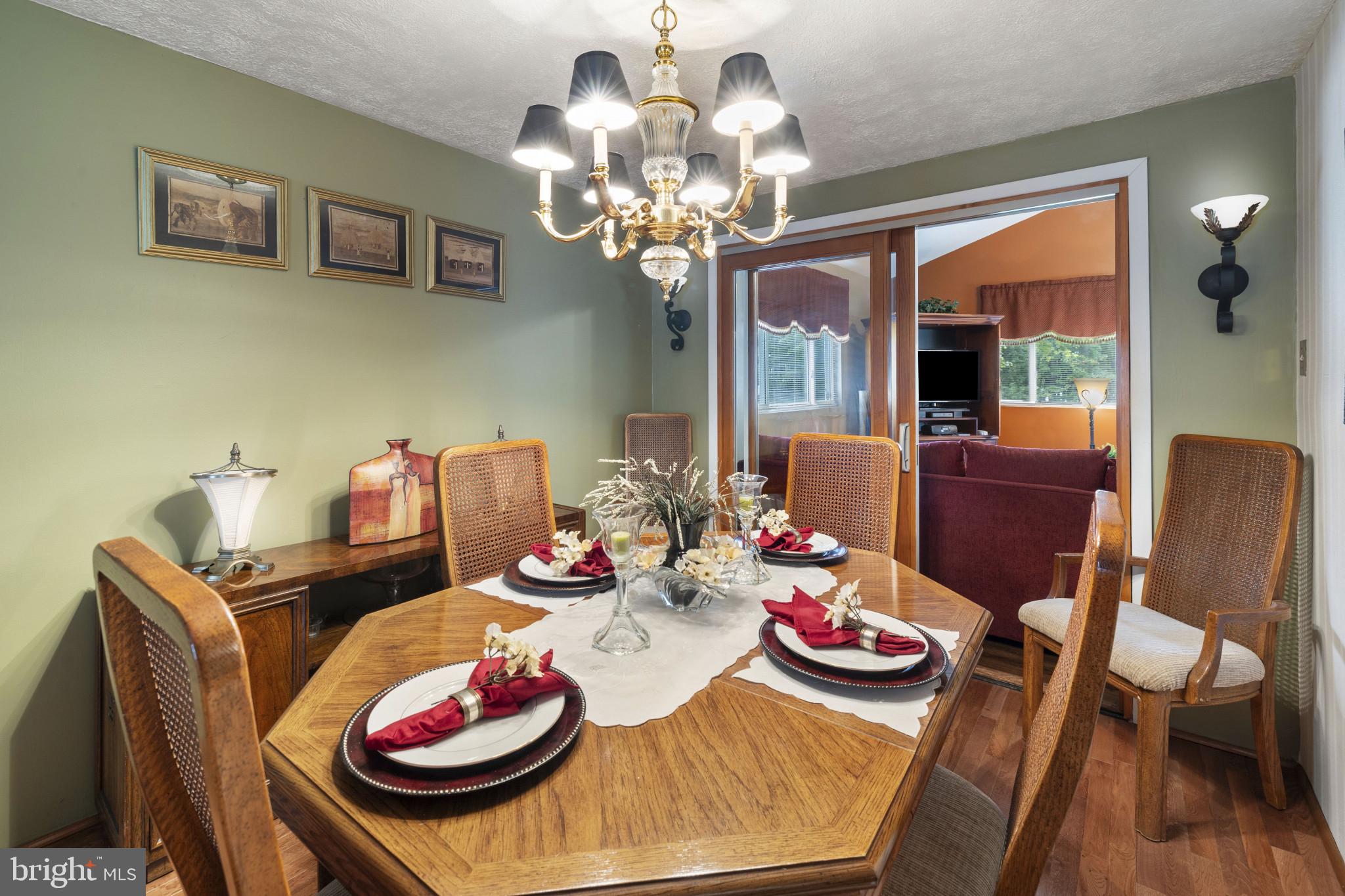 4105 Hanwell Road Randallstown, MD 21133 - Photo 15 of 37 a view of a dining room with furniture a chandelier a large window and wooden floor