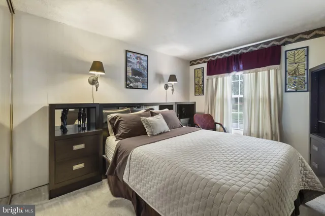 a bed sitting in a bedroom next to a window