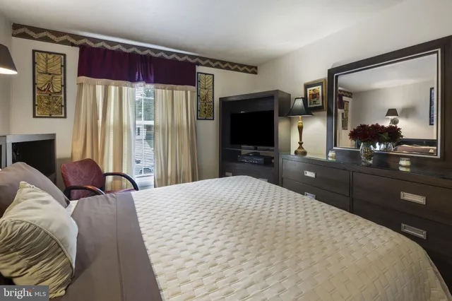 a bedroom with a bed and a flat screen tv